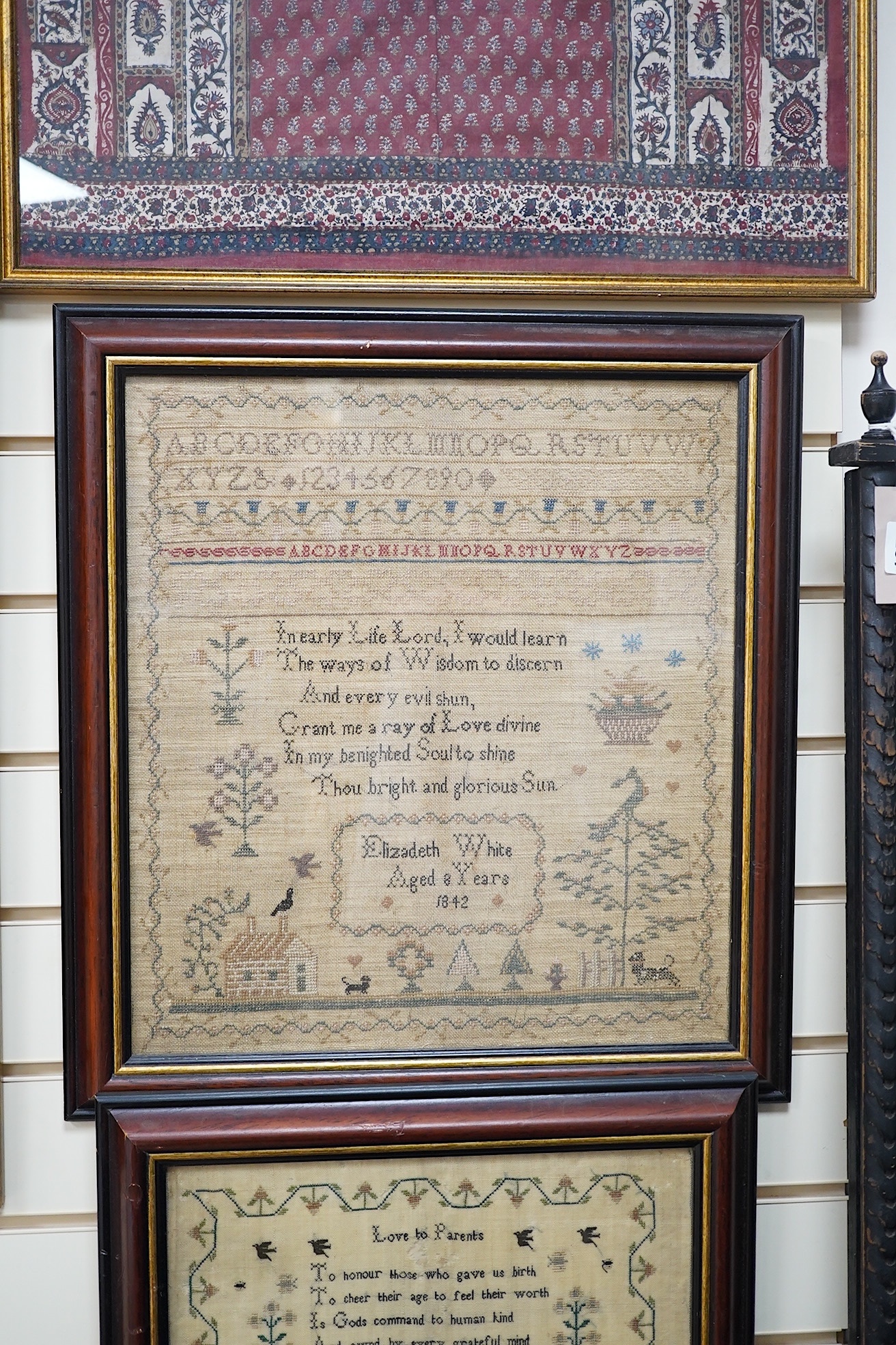 Two mid 19th century samplers worked by Elizabeth White, one dated 1842 aged 8 years, the other 1844 aged 11 years, both worked with a country scene of a house, birds, dogs and trees, the earlier sampler with a top panel